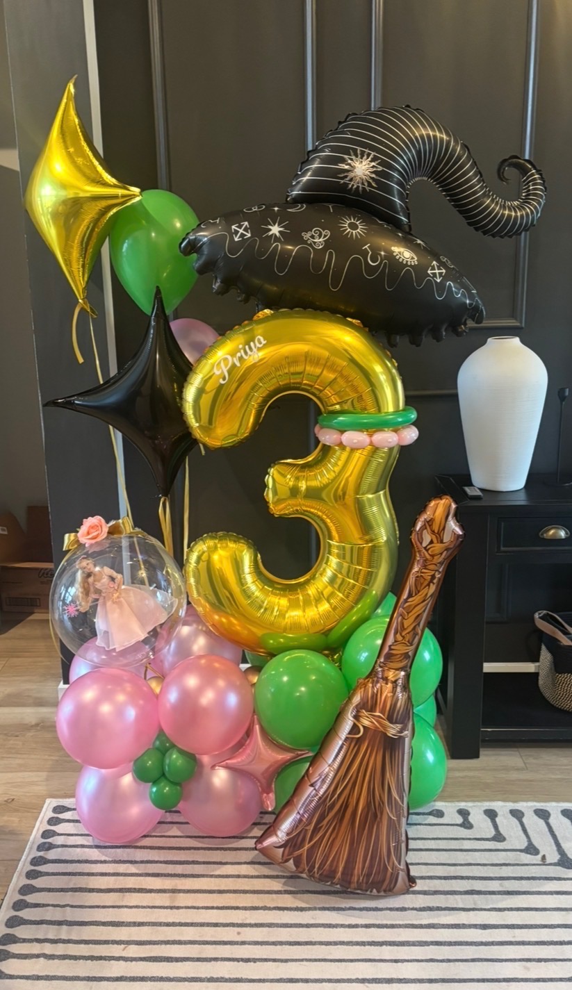 Gold number three with witch hat, broom and pink and green themed balloons