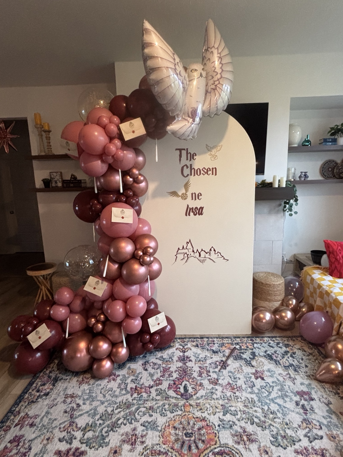Rose and burgundy balloon composition with whimsical owl-themed backdrop